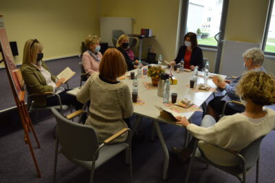 Zdjęcie grupowe Dyskusyjnego Klubu Książki przy stole..