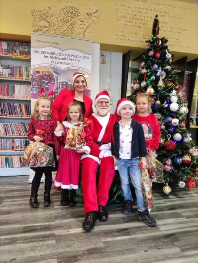 Pani opiekun z dziećmi, prezentami i Mikołajem.