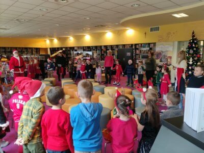 Dzieci w kółeczku razem z Mikołajem i opiekunem.