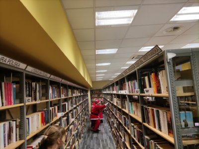 Mikołaj chowający się między regałami.