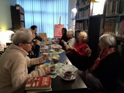 Grupa starszych Pań dyskutuję o książce przy herbatce.