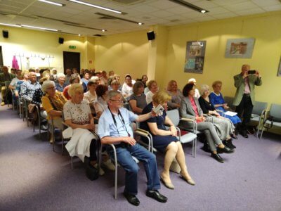 Seniorzy na sali konferencyjna podczas wykładu.