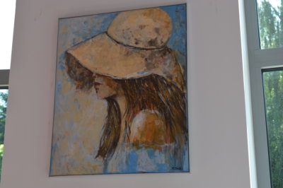 Obraz prezentujący dziewczynę w kapeluszu. Twórczość Pani Ludwiki Koczut charakteryzuje ciekawa kolorystyka i różnorodna tematyka.