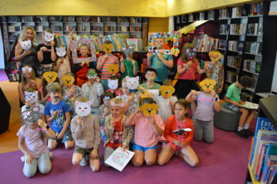 Dzieci i opiekunowie z TPD w kolorowych maskach zwierząt pozujący do pamiątkowego zdjęcia.