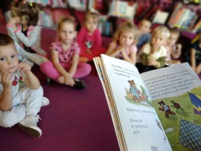 Fragment książki Franklin w bibliotece. W tle dzieci odwiedzające Wypożyczalnię dla Dzieci