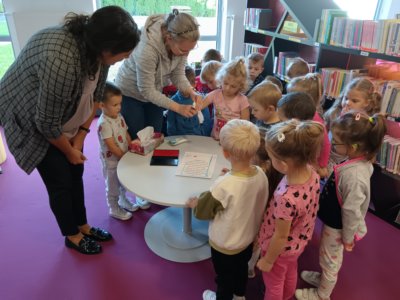 Grupa dzieci odbija odcisk palca na deklaracji małego czytelnika.