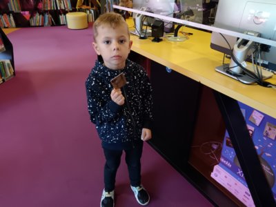 Chłopiec trzymający kartę biblioteczną.