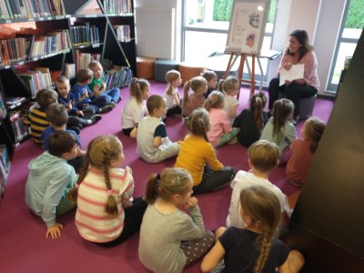 Dzieci słuchających o sercu człowieka w czytelni dziecięcej.