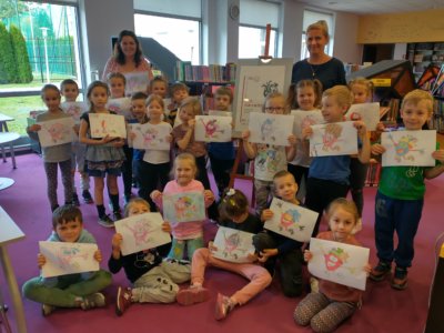 Uczestnicy zajęć edukacyjnych, prezentujący place plastyczne w Wypożyczalni Dla Dzieci