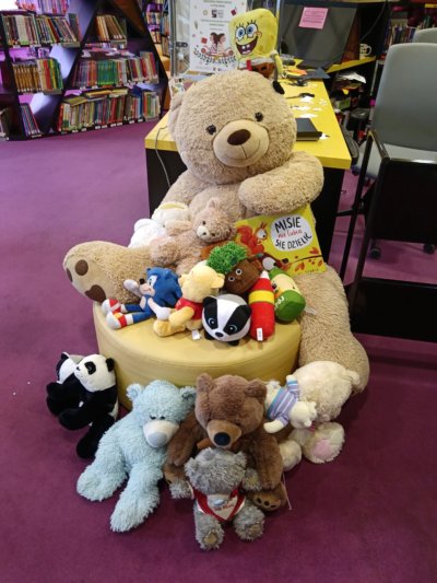 Różnego rodzaju misie leżące na pufie.