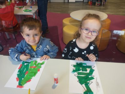 Dzieci robiące wycinankę choinki.