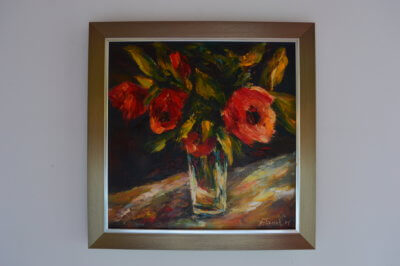 Obraz Henryka Filipczaka przedstawiający wazon czerwonych kwiatów.