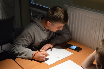 Chłopiec przepisuje tekst.