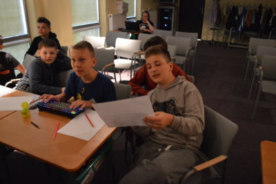 Chłopcy przepisują piosenkę do sztucznej inteligencji.