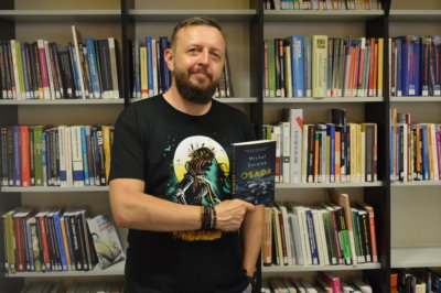 Michał Śmielak z książką Osada.