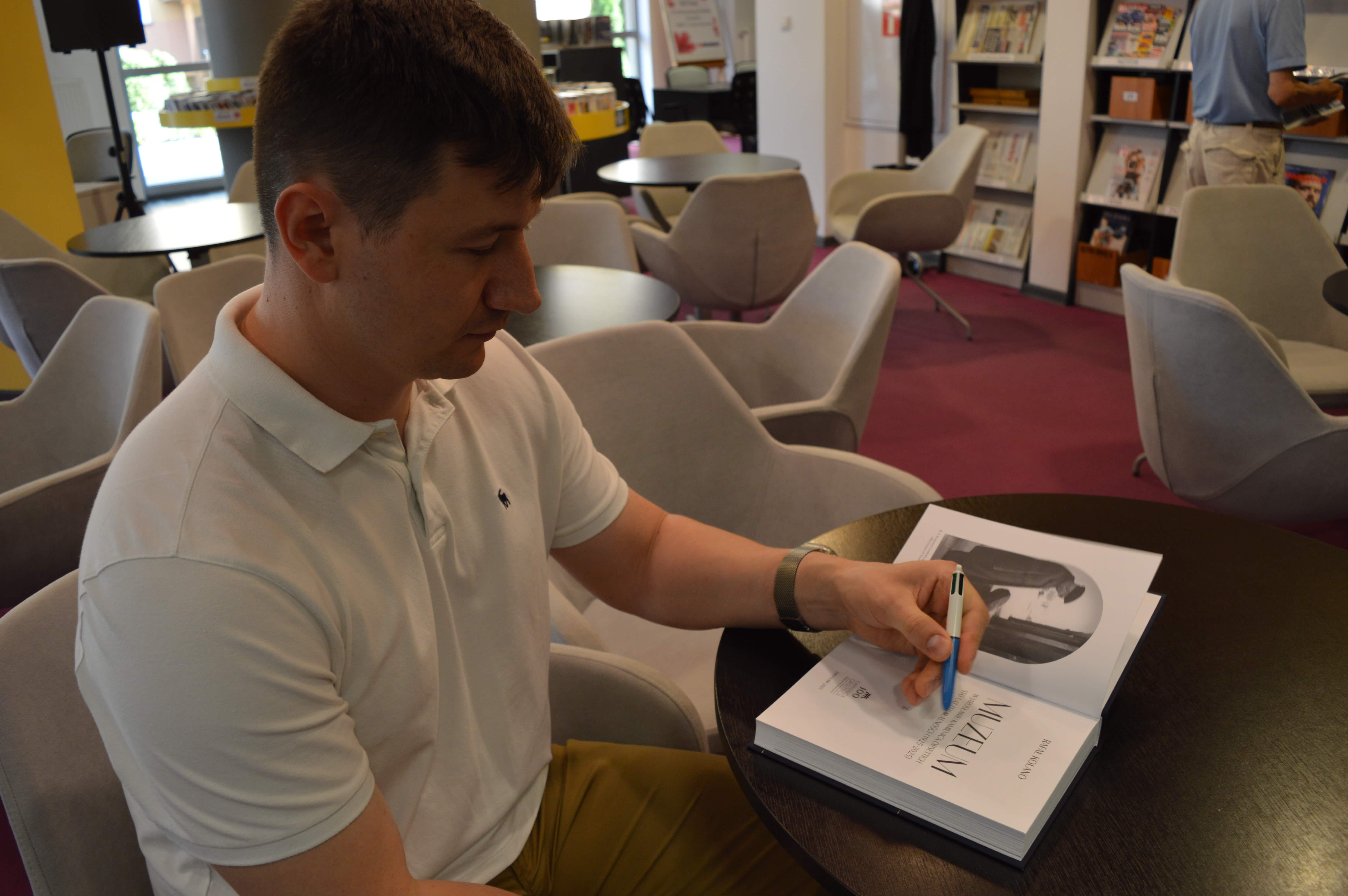 autor dr Rafał Kolano podpisuje książkę